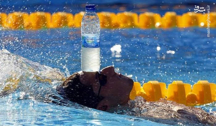 عکس/ حمل بطری آب معدنی با پیشانی در شنا